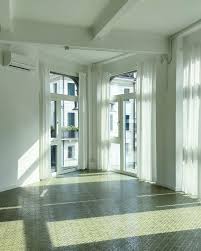 The studio: an empty room with tall windows and a terrazzo floor